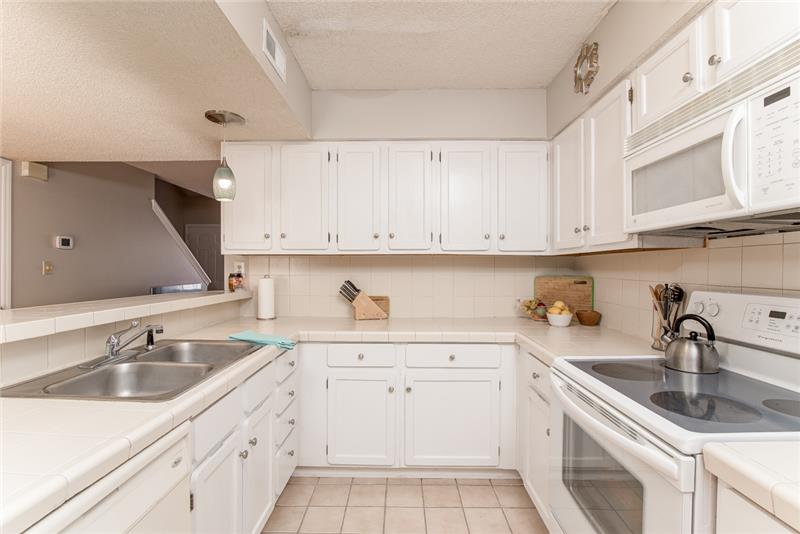 The all white kitchen is bright and provides plenty of counter and cabinet space.