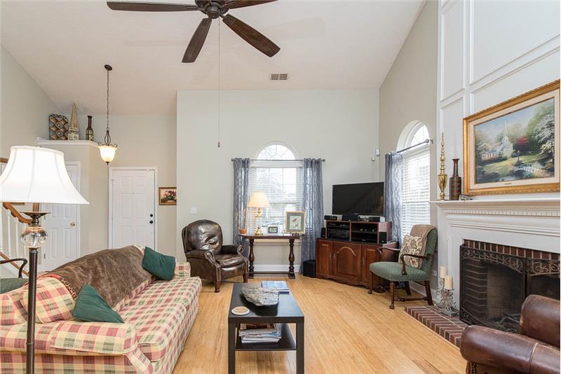 This fantastic two story great room is light and bright with the hardwood floors and windows on two sides.