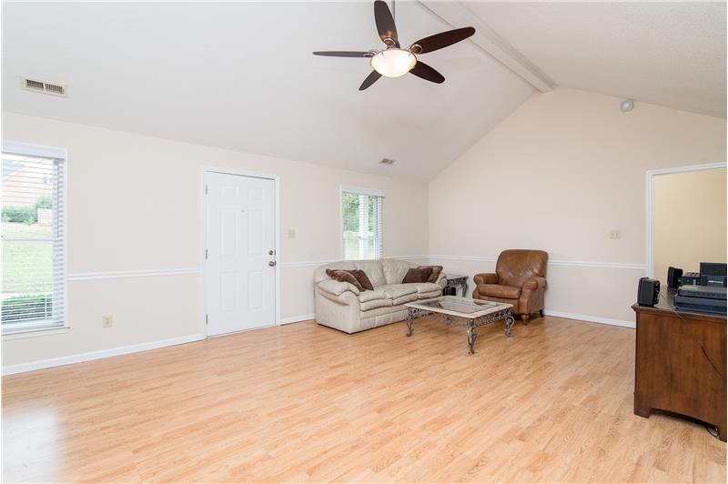 The great room is completed with laminate floors and a ceiling fan.