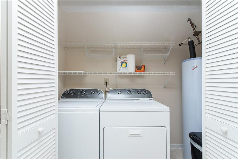 A spacious laundry area with shelving gives you plenty of space to work.