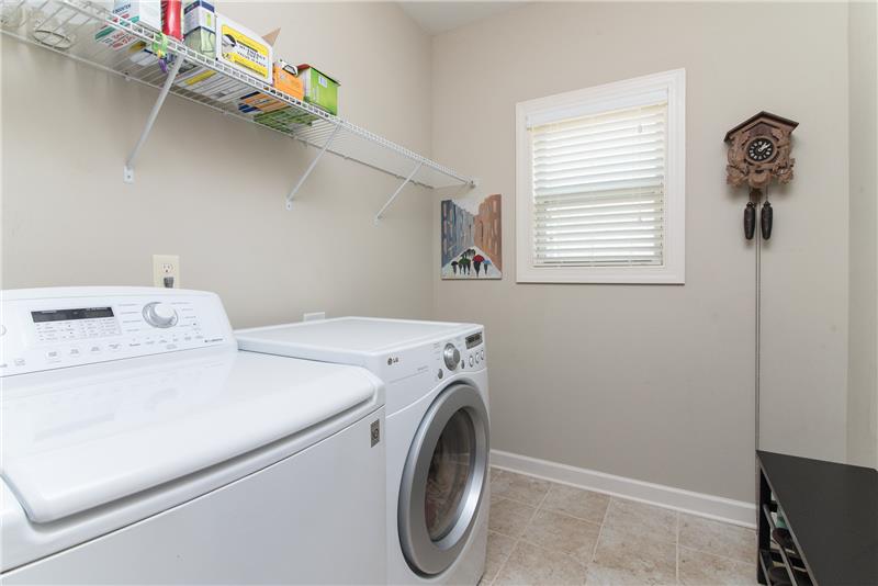 The walk in laundry room has plenty of space to work and store supplies.