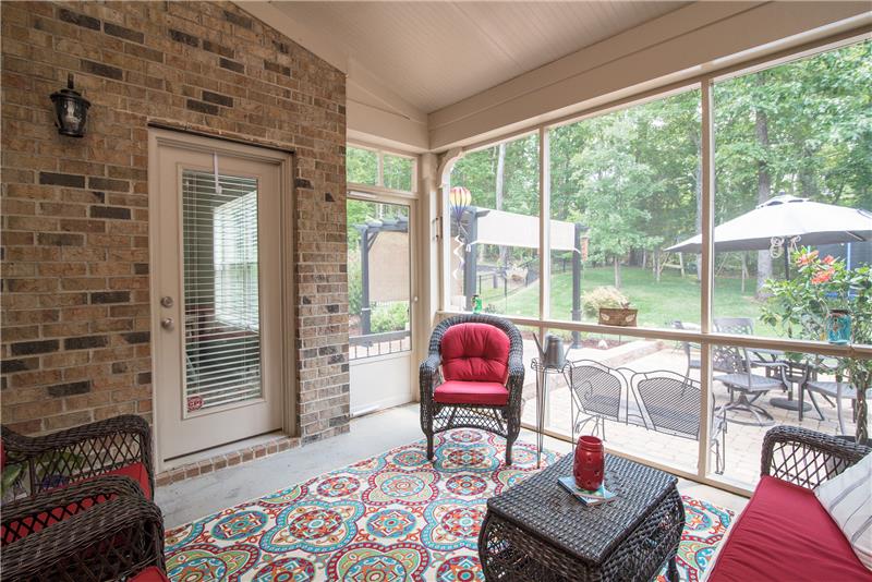 Relax outside on the screened in porch overlooking the wooded backyard.