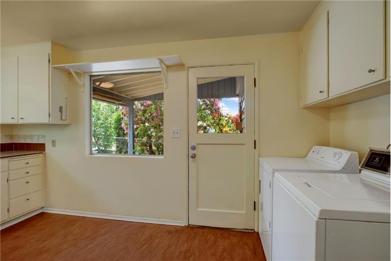 Access the kitchen directly thru this carport door. There is storage space (and the gas water heater) at the end of the carport.