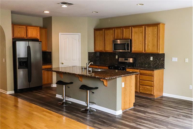 Spacious kitchen includes refrigerator, brand new dishwasher, microwave and stove. Large island opens up to family room