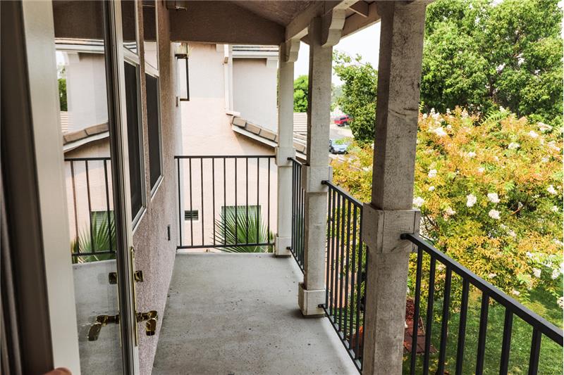 This serene balcony space overlooks this lovely neighborhood with views of the mature landscape.