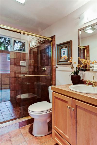 Lower level bath with beautifully tiled walk-in shower with optional double sprays, heated tile floors, and high countertop over