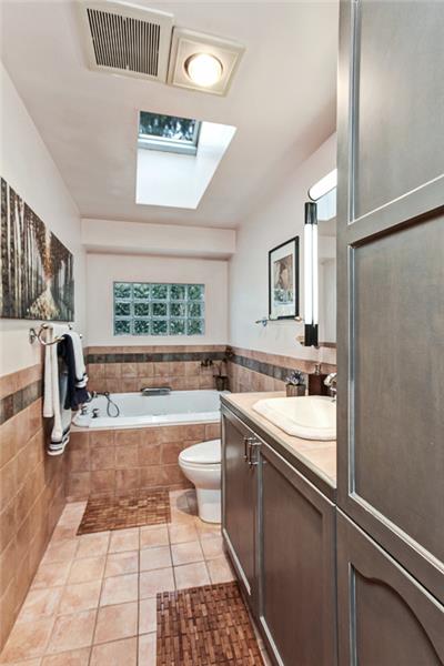 Master bathroom with heated custom tile floors. Don't miss the remote controlled skylight.