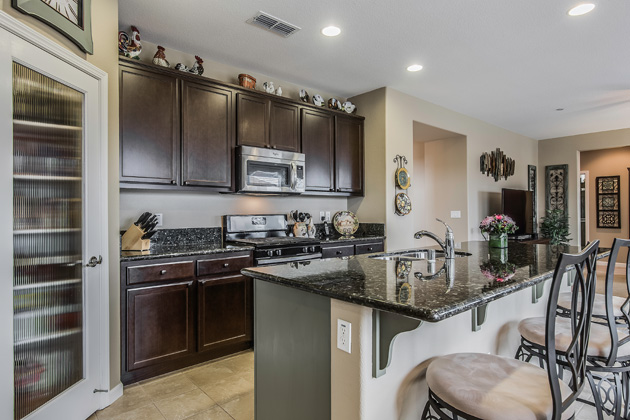 Beautifully painted kitchen cabinets and upgraded granite countertops give a custom look to the kitchen.