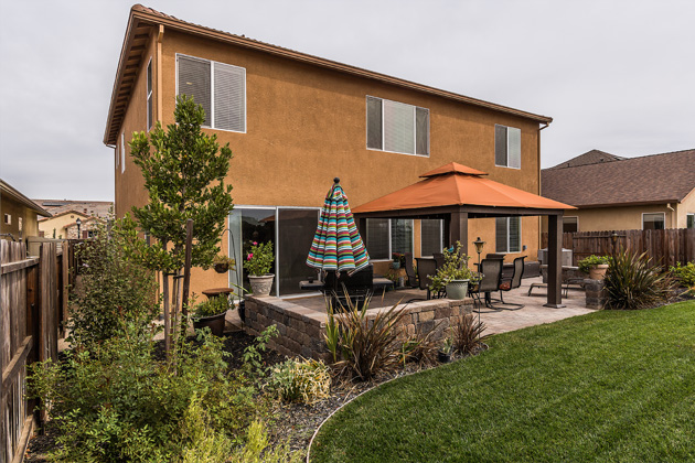 Beautifuly lanscaped backyard includes a pavered patio with built in ambiance lighting and gazebo.