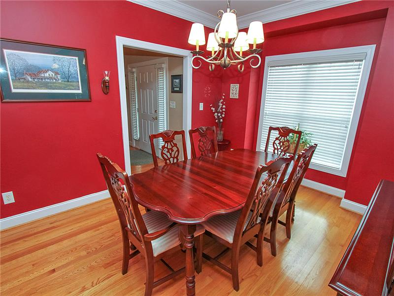Cozy formal dining with moldings and wood flooring