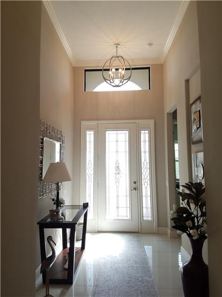 Grand Foyer w/ glass leaded front door and gorgeous 24’’x24” polished white porcelain tile throughout in the common areas.