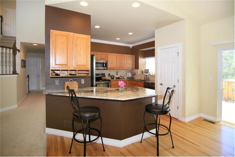 View of kitchen peninsula with slab granite counters