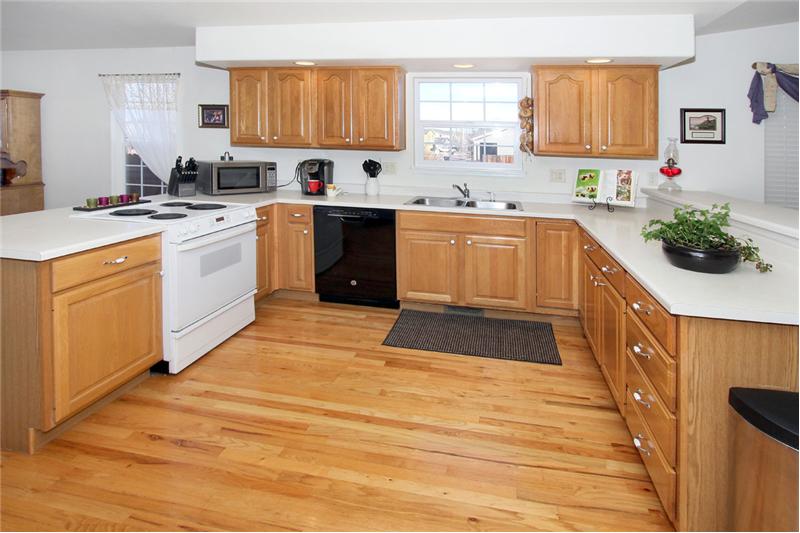 Very open kitchen with hardwood flooring and breakfast bar