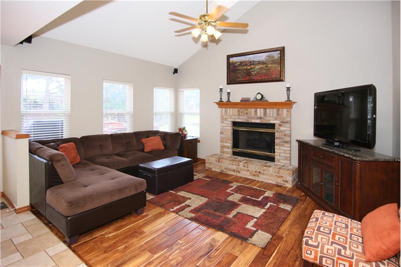 Family room with vaulted ceilings, teak hardwood flooring, a gas fireplace, and wired for surround sound!