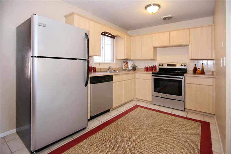 Open eat-in kitchen with tile flooring and backsplash