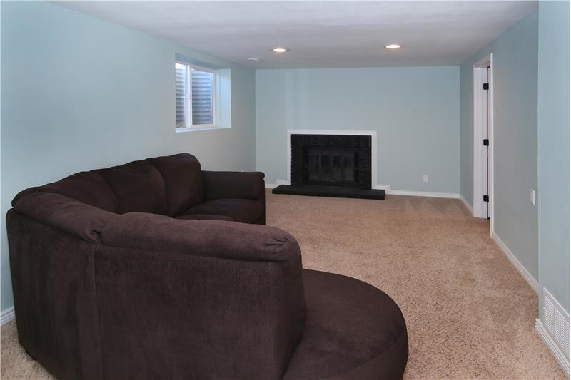 Spacious family room in basement with a wood burning fireplace!