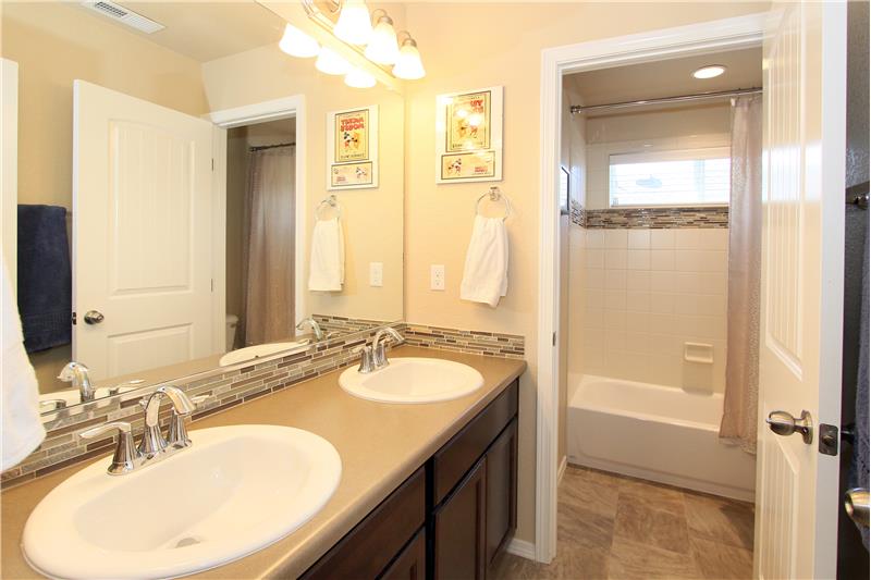 Full bathroom with double sinks on the upper level