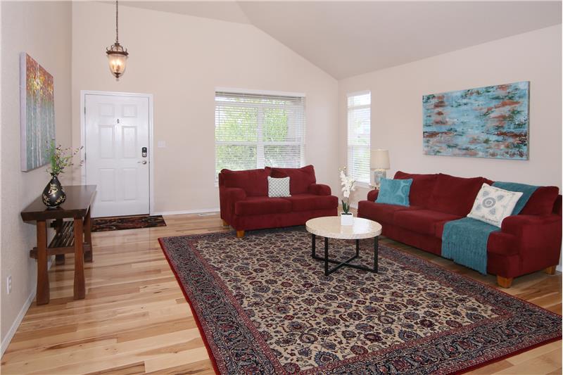 Formal living room with vaulted ceilings and beautiful hardwood flooring!