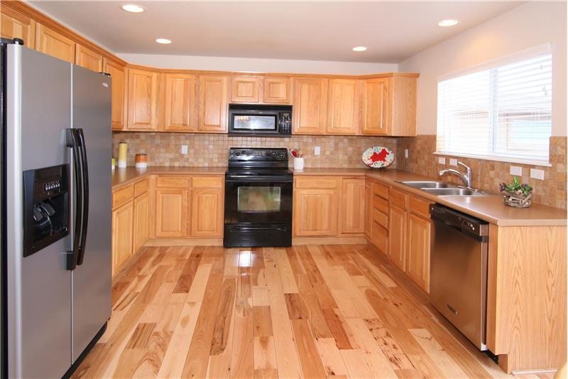 Spacious kitchen with recessed lighting, tile backsplash, and kitchen pantry