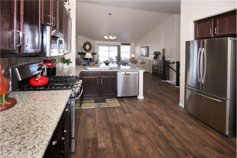 Eat-in kitchen with large pantry, wood laminate flooring, and recessed lighting