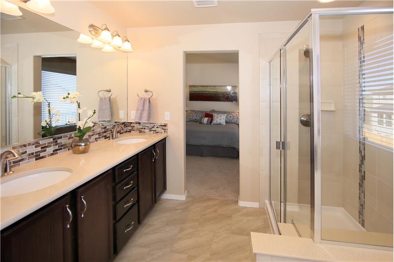 Comfort height vanity with quartz counter tops, tile backsplash, and tile flooring! Large shower with bench!