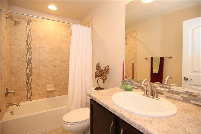 Full bath on main level with tile flooring and tile bathtub surround