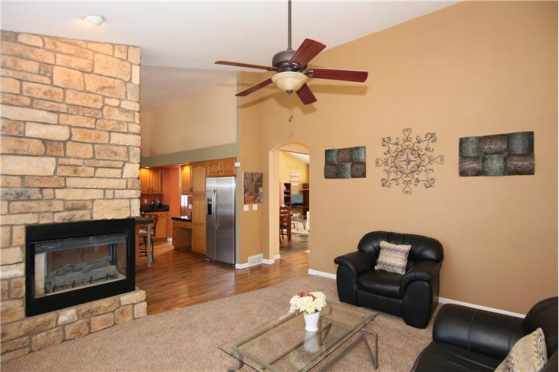 Family room with vaulted ceilings, ceiling fan, and 3-sided gas fireplace