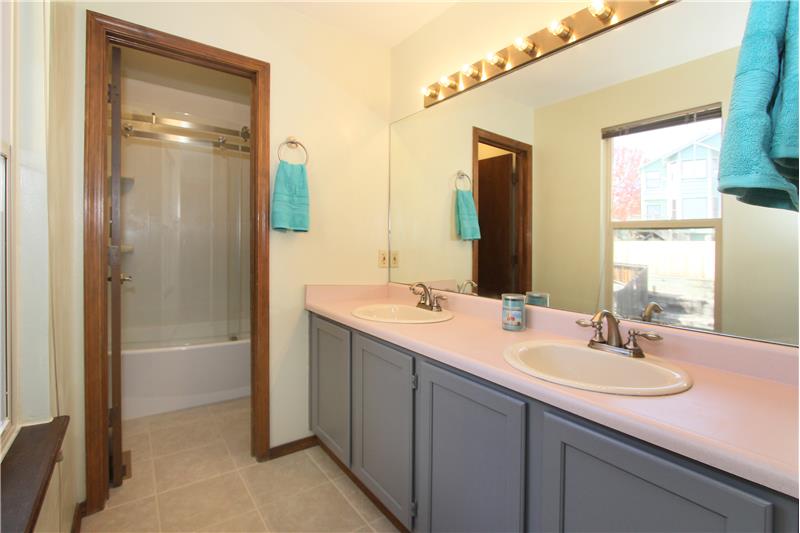 Master bath with double sink vanity, tile flooring, and updated tub/shower with tile!