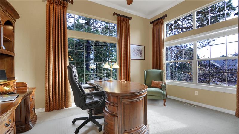 Main level office with custom window treatments, crown molding, and ceiling fan