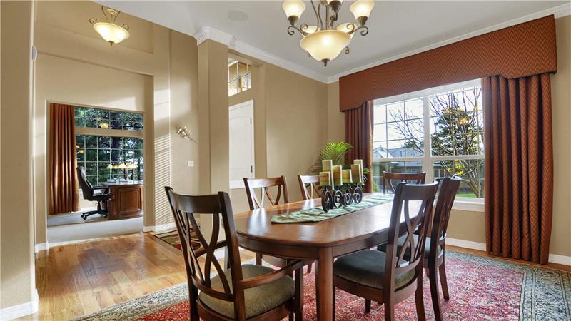 Formal dining room with in-ceiling speakers, custom window treatments, and hardwood flooring