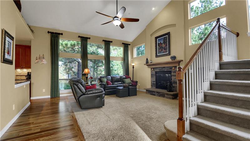 Great room with vaulted ceiling, large picture windows, and custom window treatments