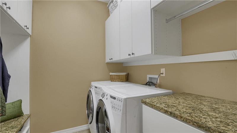 Main level laundry/mud room with cabinets and plumbed for sink