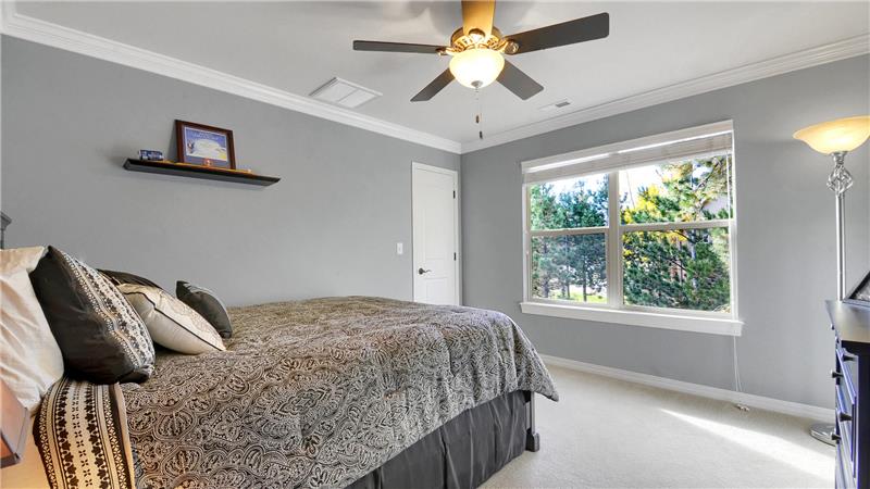 Bedroom 3 with crown molding, ceiling fan, and walk-in closet with an additional storage area
