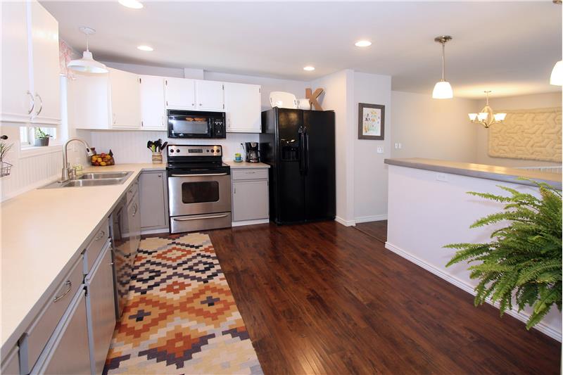 Updated kitchen with recessed lighting, ample counter top space and storage, and a modern backsplash