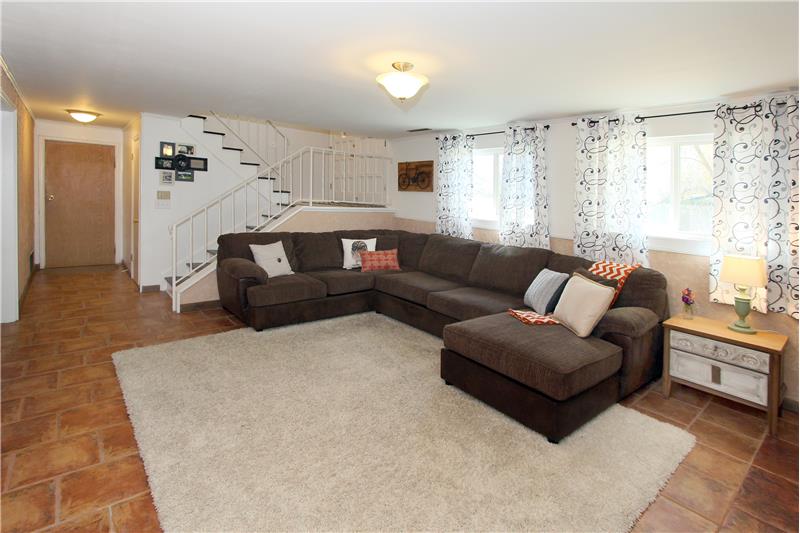 Lower level family room with large windows and tile flooring