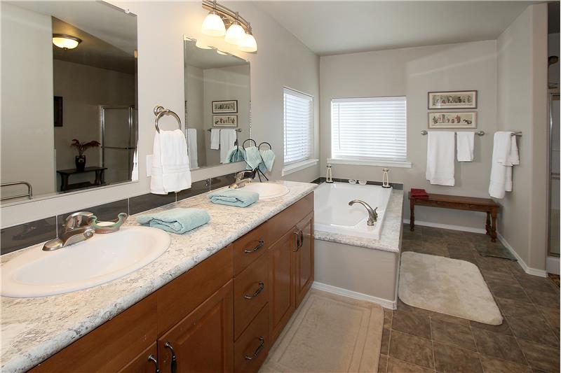 Master bathroom with a large double sink vanity and a deep soaking tub.