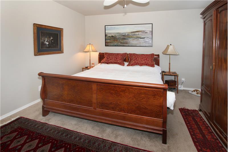 Master bedroom with ceiling fan, adjoining 5-piece bath, and walk-in closet.