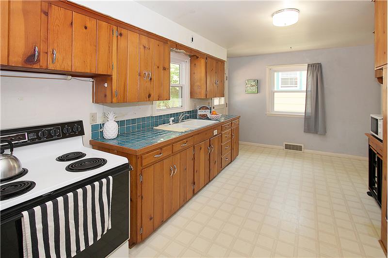 Kitchen with tile counter tops and plenty of room for cooking and storage