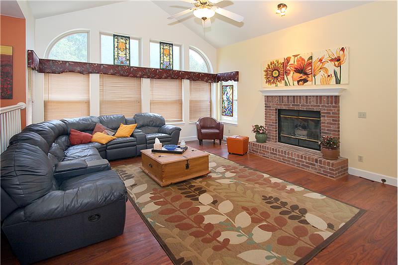 Spacious family room with vaulted ceilings and brick fireplace