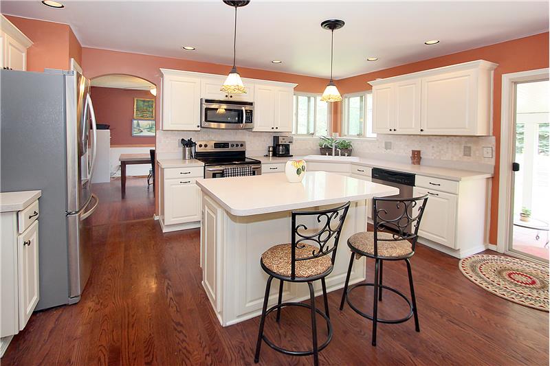 Updated kitchen with quartz counter tops, tile backsplash, and stainless steel appliances