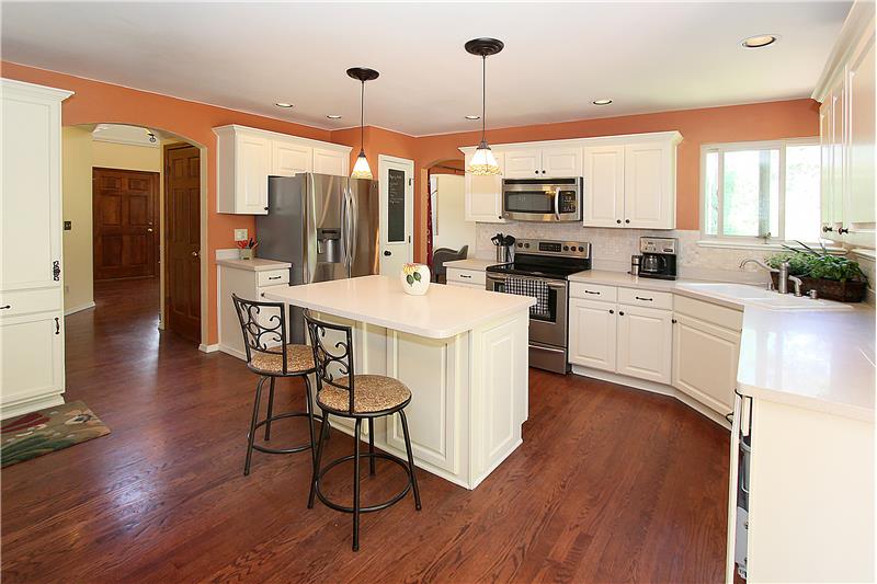 Recessed lighting, plentiful cabinets, and hardwood flooring
