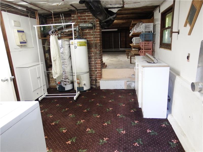 The huge basement has multiple rooms and areas for storage. The exterior entry door will lead you into this laundry room. On the