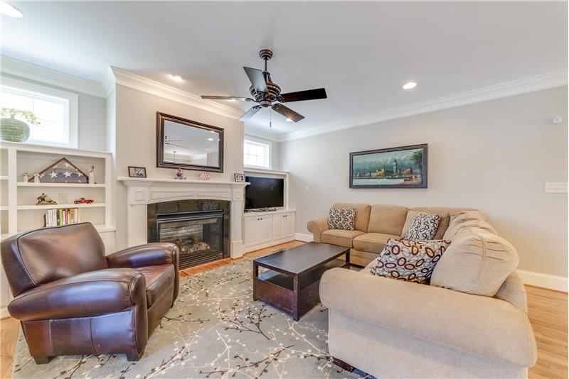 Spacious family room with wood floors, crown molding & ceiling fan