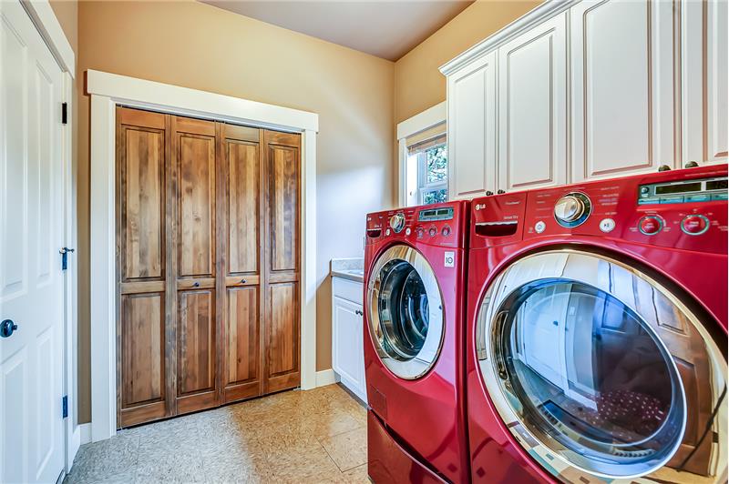 Sizeable laundry room off kitchen leads to garage and features a utility sink as well as abundant storage.