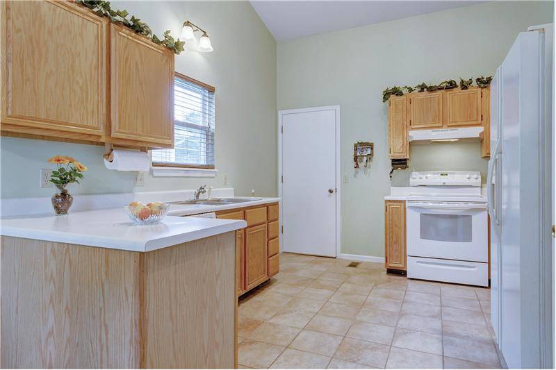 Bright kitchen has tile floor and miles of counters