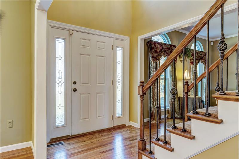 Entry Foyer with wood floor, door side lights, wrought iron premium stair balusters.