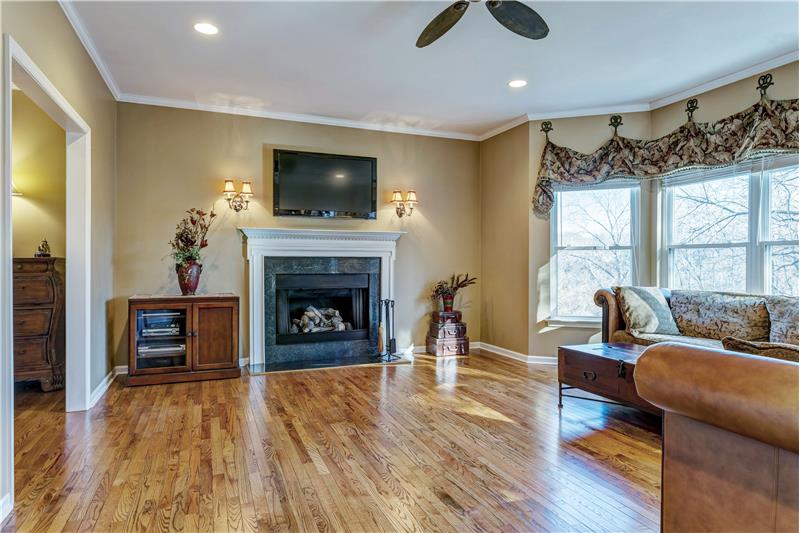 Family room, with a beautiful fireplace, wall sconces, ceiling fan, light & bright!