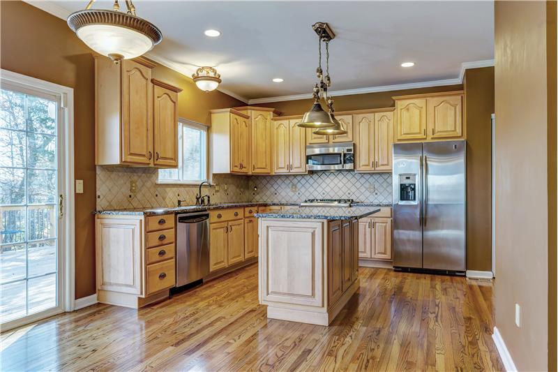 Gourmet kitchen w/SS Appliances. Crown molding,custom cabinet end panels, wood floor, replaced light fixtures