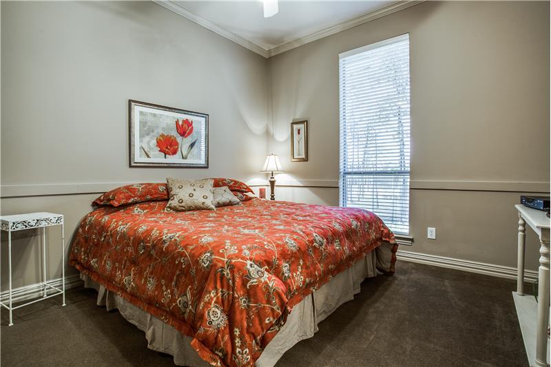 Guest bedroom is split from master and features large walk in closet, high ceiling and its own bath