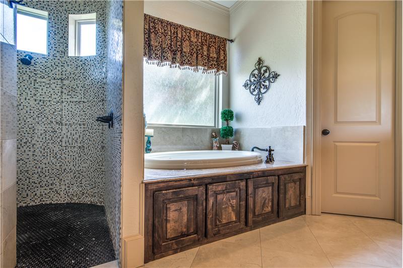 Master bath features a dual shower and jetted tub